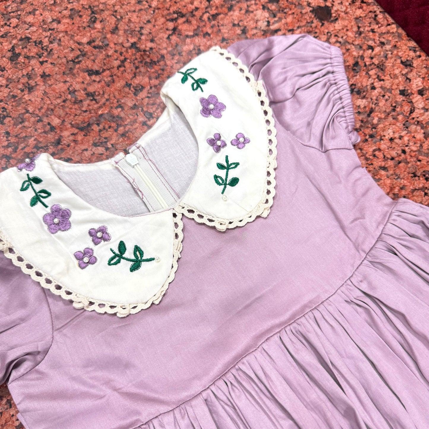 Close-up of collar showing purple violet embroidery clusters with pearl bead accents