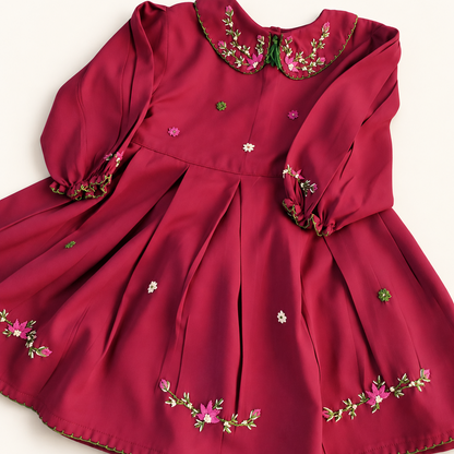 Deep red embroidered girls dress on a warm backdrop