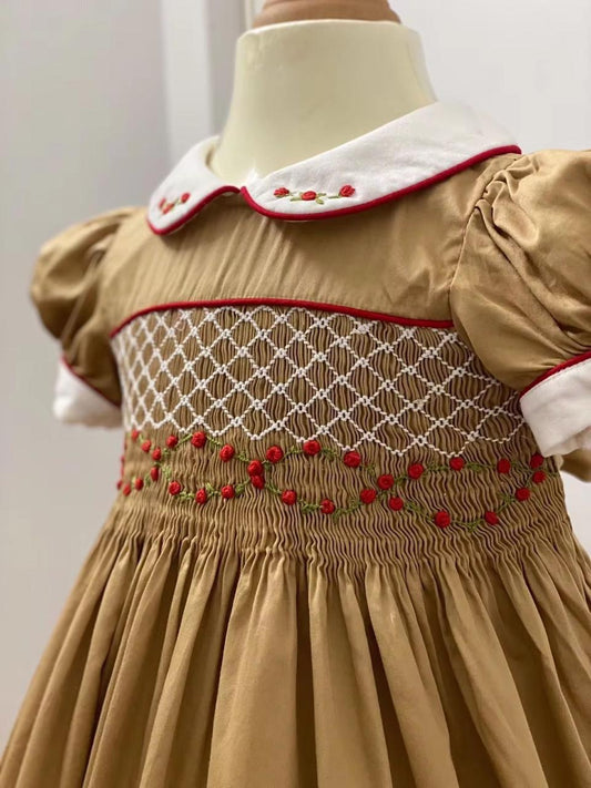 Front close-up of golden caramel smocked dress showing diamond lattice smocking and red rose embroidery