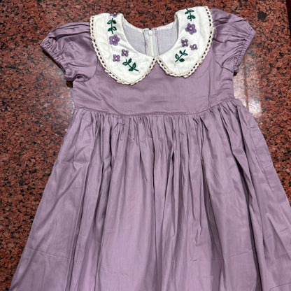Full view of lavender hand embroidered girls dress laid flat