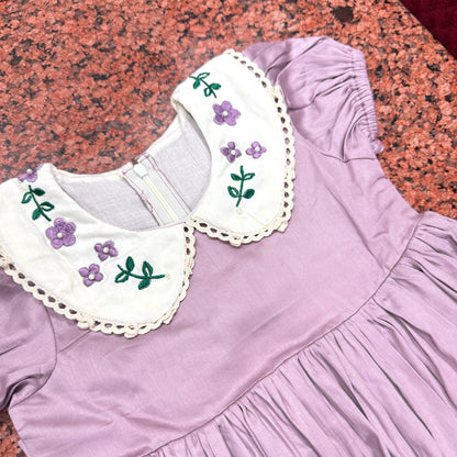 Close-up of collar showing purple violet embroidery clusters with pearl bead accents