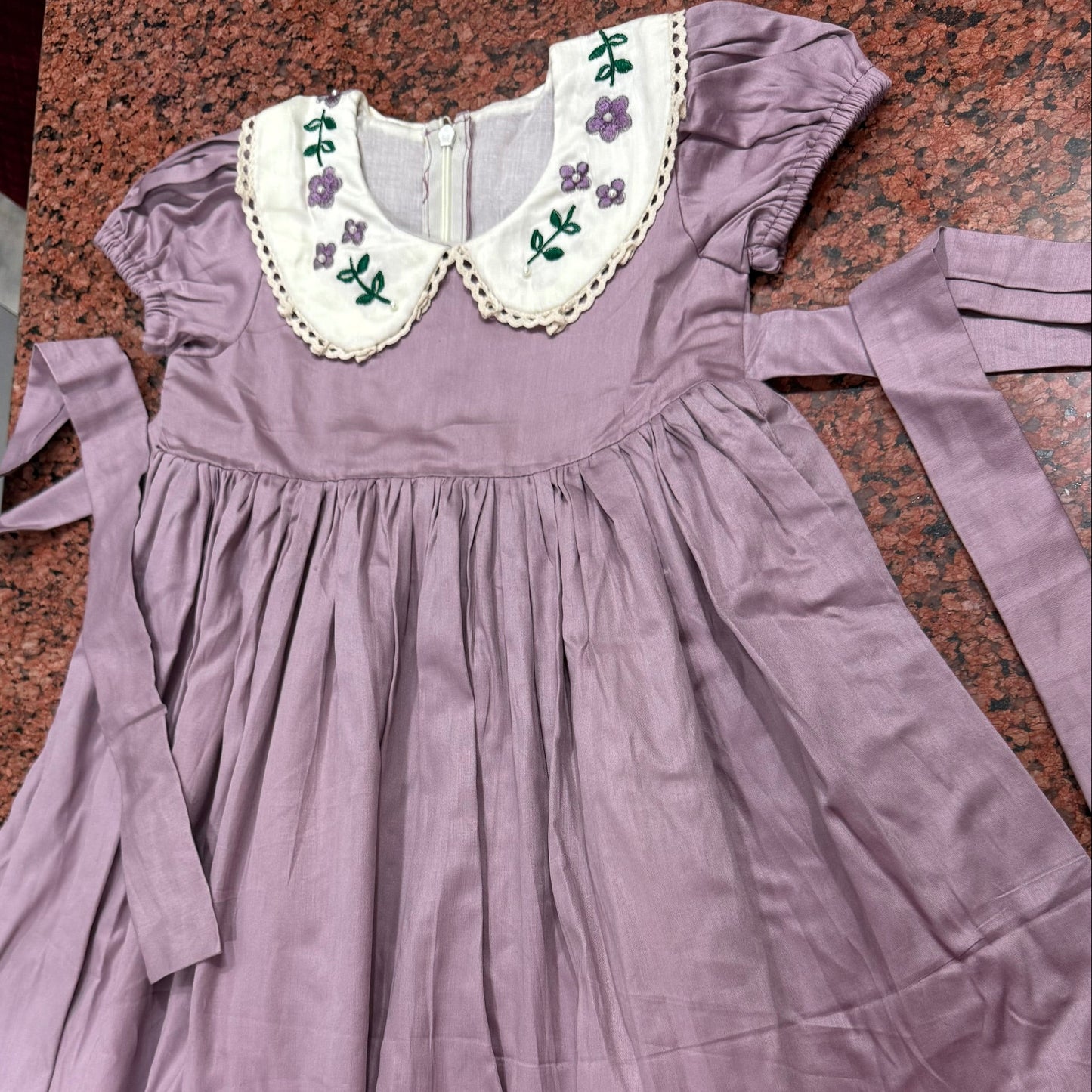 Three-quarter view of lavender dress showing puffed sleeves and full skirt